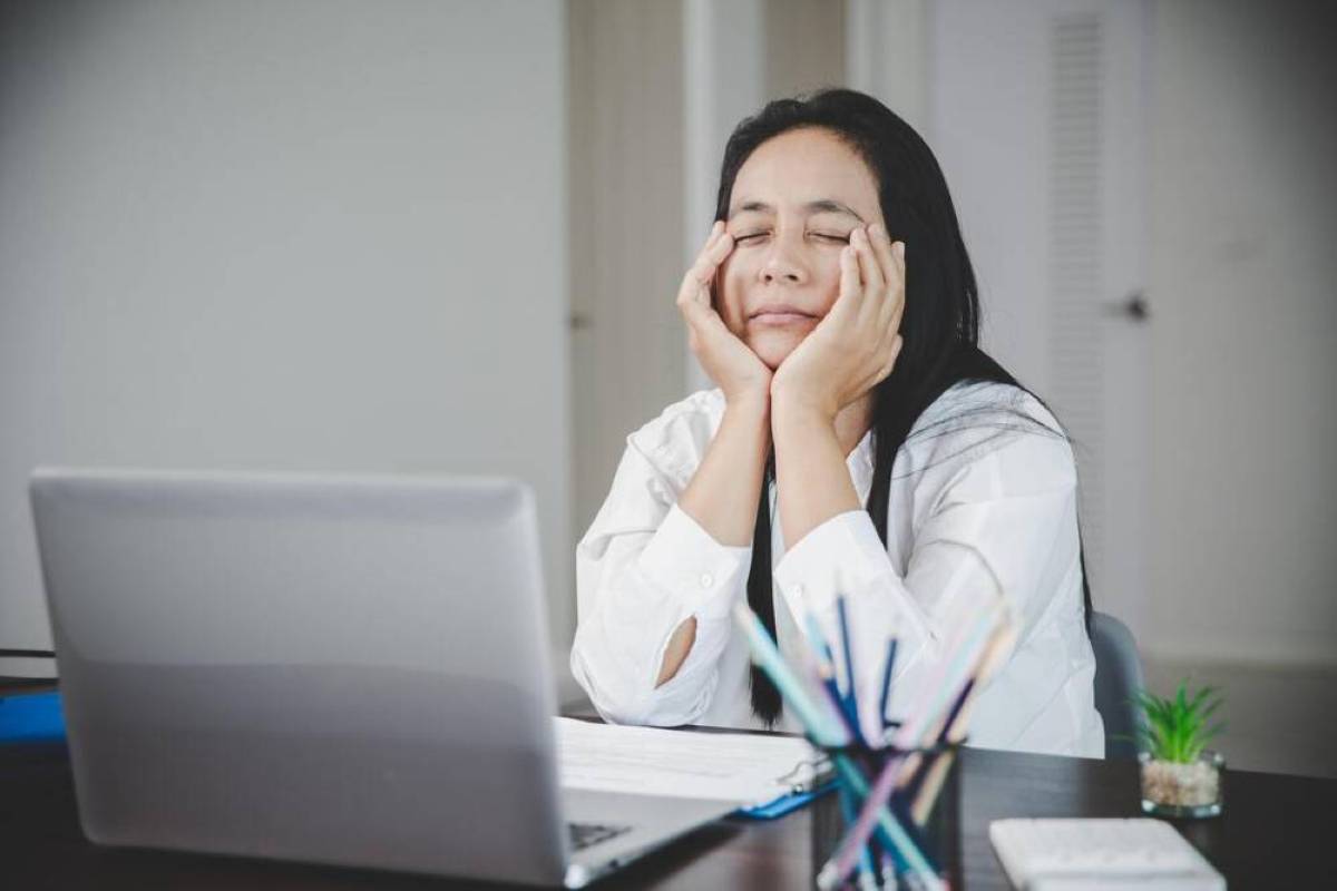 Vermoeide vrouw achter laptop bij een blog van Perfect Lab over vitamine B12-tekort
